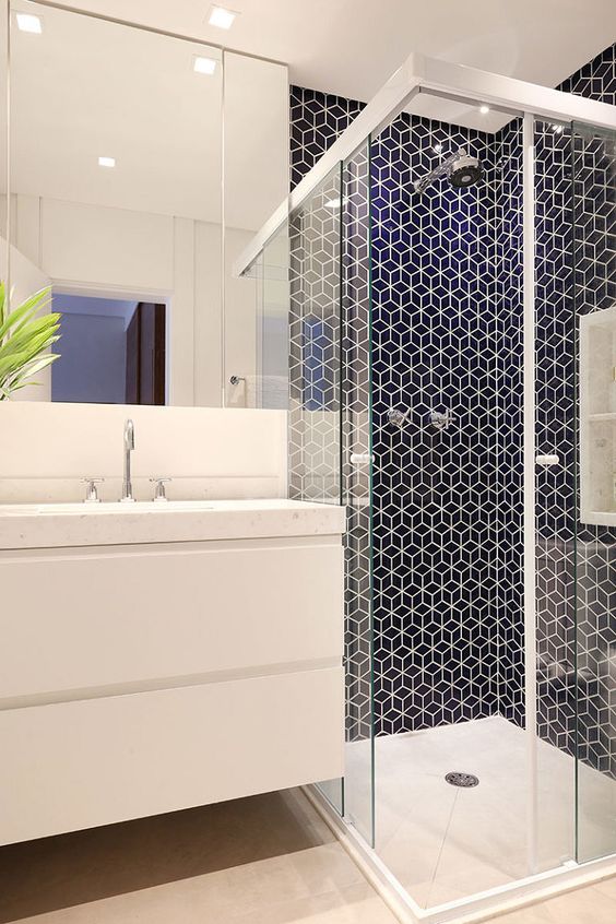 Banheiro com pastilha de hexagonal azul no box com piso e bancada branca