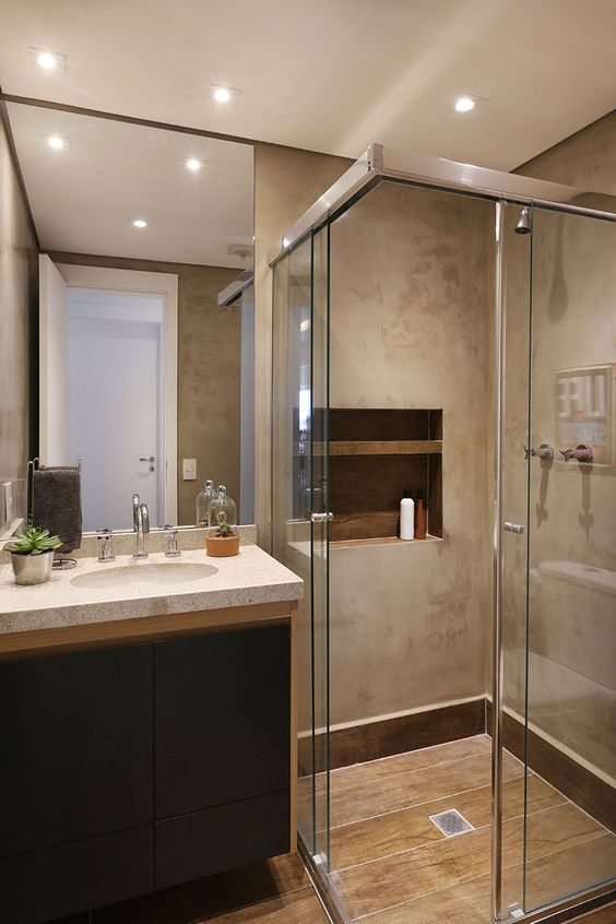 Banheiro com paredes com cimento queimado e piso com porcelanato que imita madeira