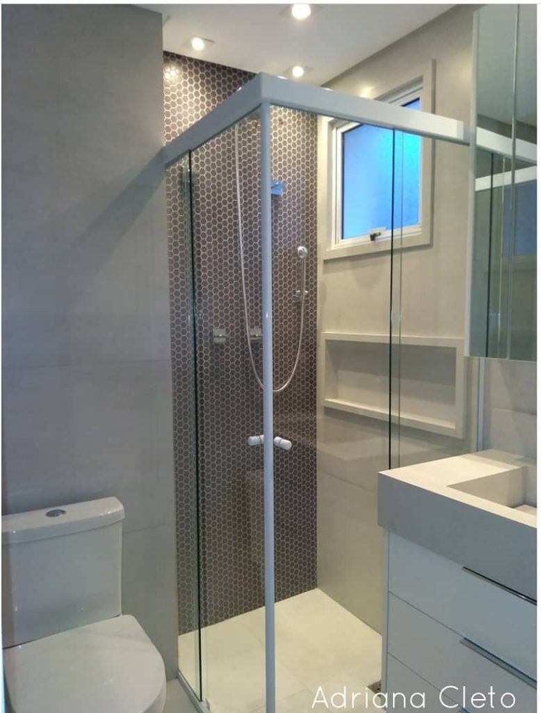 Banheiro com pastilha hexagonal grafite e porcelanato cinza claro.