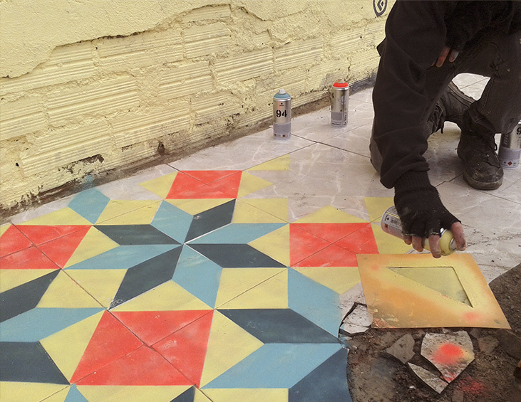 Artista Javier de Riba pintando ladrilho geometrico no chão feito de Stencil