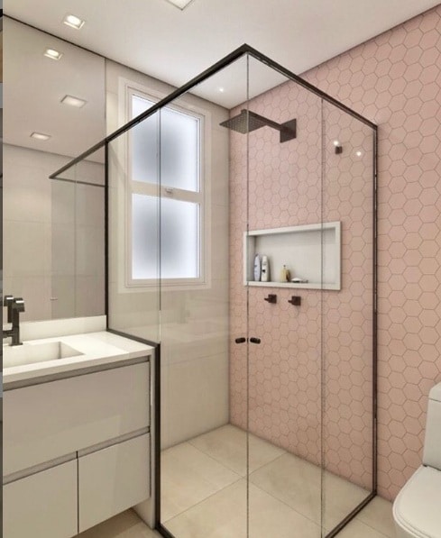 Box com pastilha hexagonal rosa, piso de porcelanato que reproduz cimento queimado e os metais e esquadria do box na cor preta. Projeto da Premazzi Favorito interiores